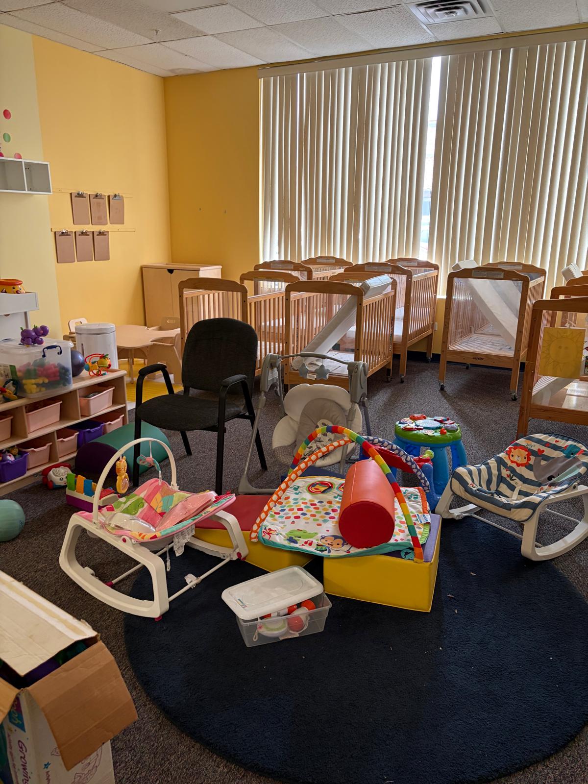 Infant and toddler room with cribs and play mats