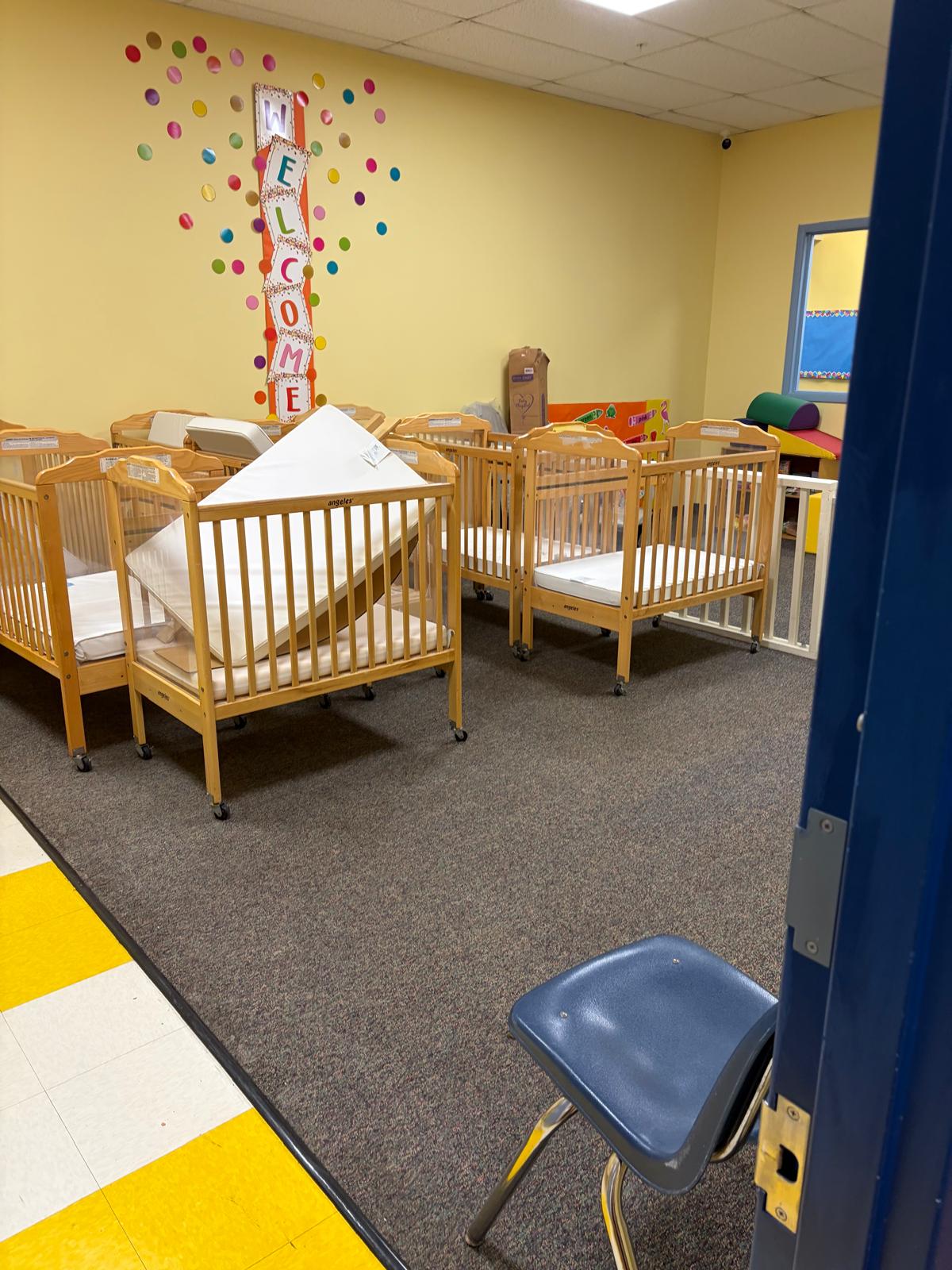 Nursery room with cribs and colorful wall decor